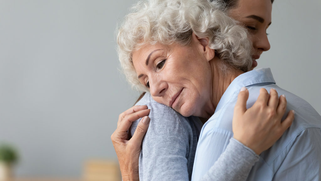 Elderly woman embracing a younger family member, symbolizing warmth and care, related to home heating assistance from Alto Gas.